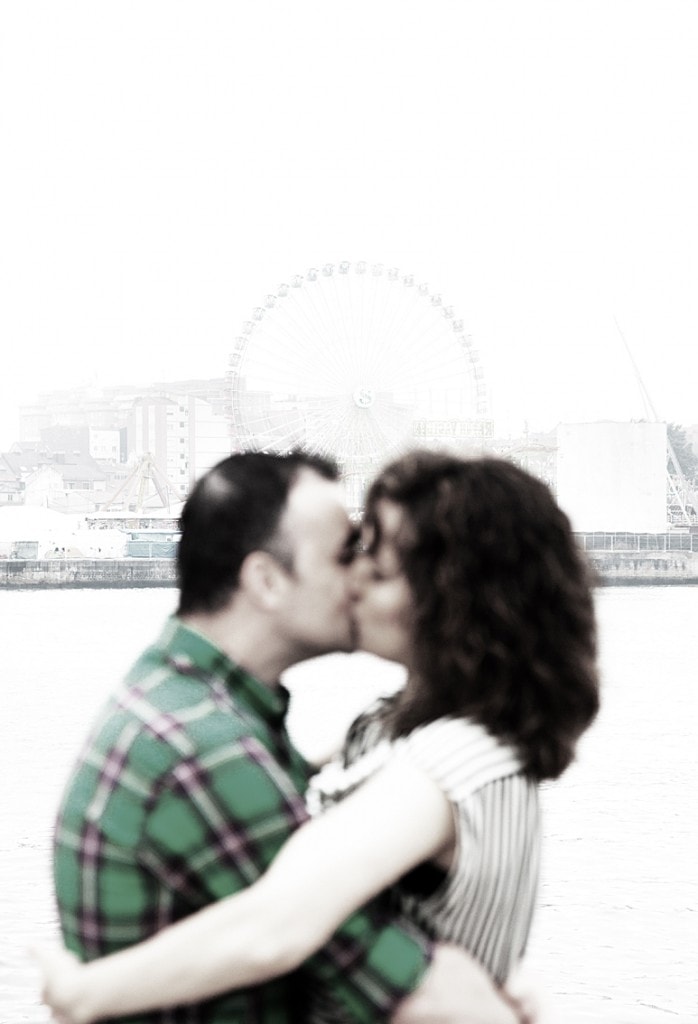 Couple kissing with the Ferris wheel in the background