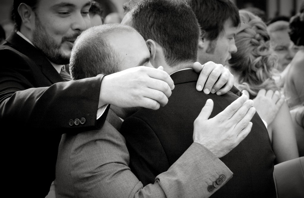 Family members hugging the groom